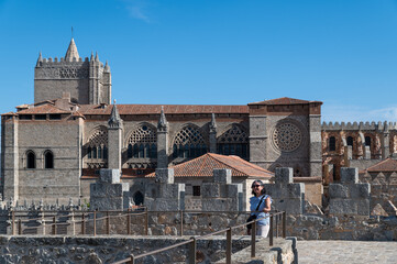 Woman with hat walking on the wall surrounding the old town of the Spanish city of Avila (Spain) on...