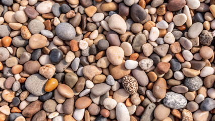Naklejka premium Assorted smooth pebbles texture, natural stones, close-up background, earthy tones with copy space