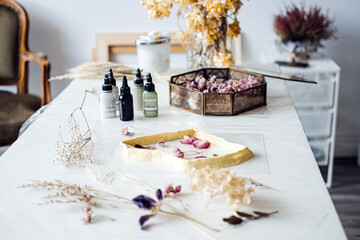 Dried flower crafting setup on a table with resin mold and pigments. Natural decor, floral art, DIY home decoration, sustainable crafts, interior styling.
