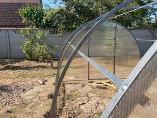 Installation of a metal frame greenhouse with polycarbonate covering