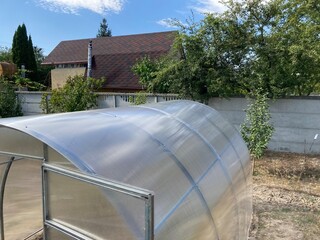 Installation of a metal frame greenhouse with polycarbonate covering