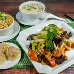 salty chijaukay with vegetables and chicken meat, served with chaufa rice, siu mai and wuantan soup. chifa, peruvian food