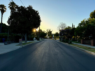 generic US residential street (driveways, houses, parked cars, telephone poles, trees, street signs, mailboxes, lawns) at sunset - Los Angeles, California, USA