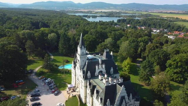 Stunning 4K drone footage of Budmerice Castle in Slovakia. Discover breathtaking aerial views of this picturesque 19th-century castle surrounded by lush greenery and beautiful gardens
