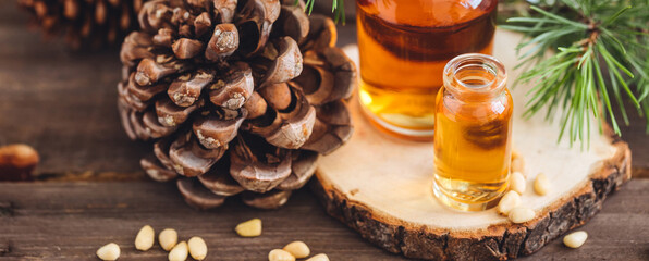 Christmas home aromatherapy. Aroma diffuser with pine extract, organic essential oil, cedar and spruce cone, candles on wooden table. Cozy atmosphere holiday spirit. Winter inspiration and mood banner