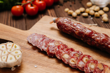 Sliced sausage with pistachios on wooden board, ideal for food presentations and gourmet displays