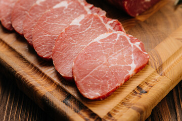 Fresh raw pork loin with rosemary on a wooden cutting board, perfect for cooking or grilling recipes