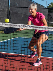 Female pickleball player laughing while playing a.tif