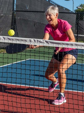 Female pickleball player laughing while playing a.tif
