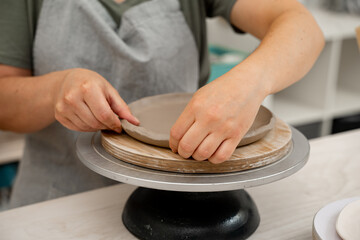 Creating ceramic products from flat sheets of clay. Using hands to model a form for a clay project....