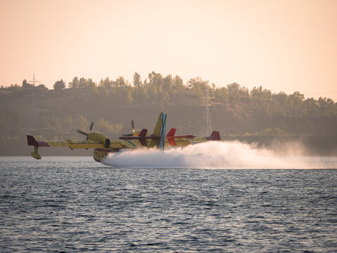 Ponferrada, Leon, Spain; 08-19-2024: Canadair CL-215 seaplane from the 43rd Air Force Group of the Spanish Air Force during the maneuver to collect moving water in a reservoir to extinguish a fire