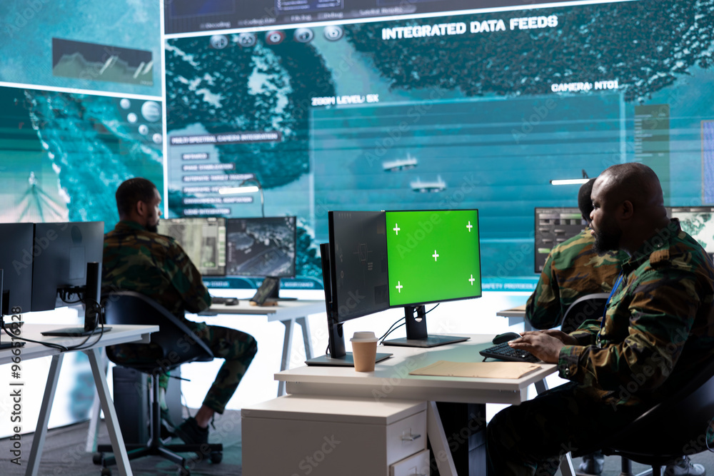 Poster soldier gathering real time surveillance data next to mockup display in high tech command center, pr