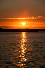 beautiful sunset with sun and orange sky on the lake