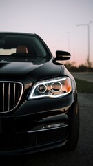 The headlights and the hood of a black luxury car.