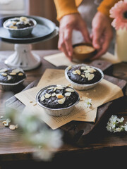 Choco lava cupcakes with almond sliced. Served on a cutting board on the dining table.