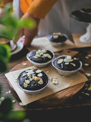 Choco lava cupcakes with almond sliced. Served on a cutting board on the dining table.