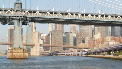 New York City Manhattan Bridge to Brooklyn. Waterfront downtown skyline cityscape, USA financial district skyscrapers from Pier 35. East river iconic view, morning sunset. Riverfront architecture.