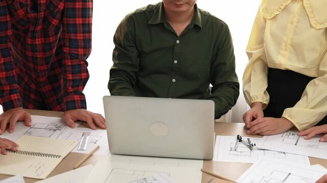 Smart architect and safety engineer discussion about building plan on table with architectural document, measurement tools and wooden block scatter around at modern office. Closeup. Delineation.