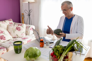 Male doctor dressed in white lab coat telling about importance of healthy diet.