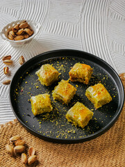 close up look of turkish baklava, turkish traditional sweet desserts. made of philo pastry sheets, filled with pistachio ground and doused with syrup. isolated on white background with copy space