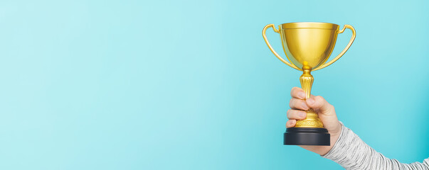 Businessman or boss holding champion golden trophy for winner, success and achievement award in business concept. Man in a suit with a gold trophy prize on blue background.