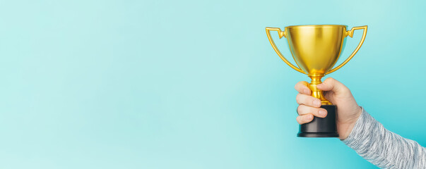 Businessman or boss holding champion golden trophy for winner, success and achievement award in business concept. Man with a gold trophy prize on blue background.