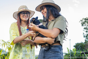 Two sisters enjoying an afternoon vacation at a resort, petting their pinscher dog