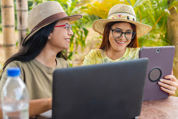 Two Latina women enjoying their work while traveling, representing the concept of online work on...
