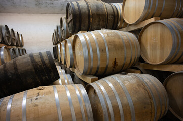 Aging process of cognac spirit in old dark French oak barrels in cellar in distillery house, Cognac...