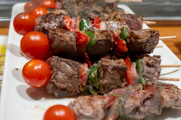 Typical snacks of Basque Country, pinchos or pinxtos skewers with small pieces of bread, fish, sea food, sweet green pepper served in bar in San-Sebastian or Bilbao, Spain