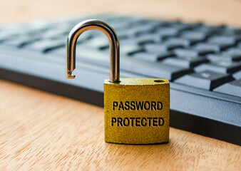 Password protected text engraved on padlock with laptop keyboard background. Password security...