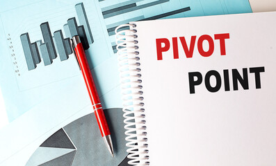 Pivot point concept on a notebook with business charts and a red pen on a desk