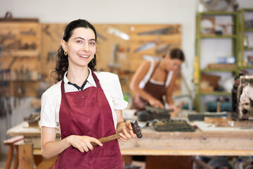 Portrait of girl working in carpentry workshop. She make decorative objects products, learns to...
