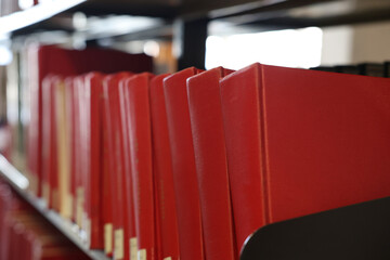 A close up image of a line of blank empty red text books on a library shelf. School library,...