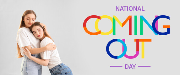 Young lesbian couple hugging on light background