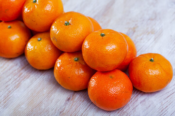 Whole fresh juicy clementines on pile on wooden table. Vitamin cooking ingredients © JackF