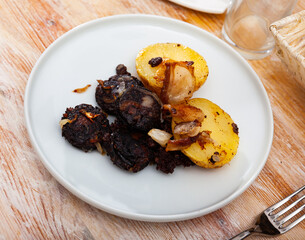 Delicious blood sausages with garnish of potatoes and grilled onion