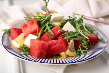 Plate of tasty watermelon salad on white wooden background