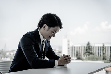 パワハラなどのストレスで悔しい・怒る・悲しい・辛い落ち込むビジネスマン
