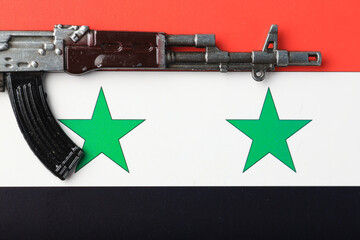 A toy gun is placed on Syria flag
