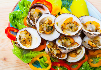 Baked in oven European bittersweet clams served with boiled potatoes, fresh vegetables and greens