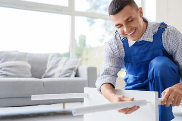 Male worker assembling furniture in room