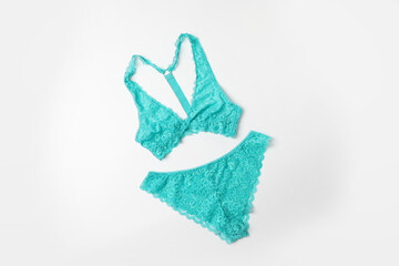 Elegant turquoise lace women's underwear on white background, top view