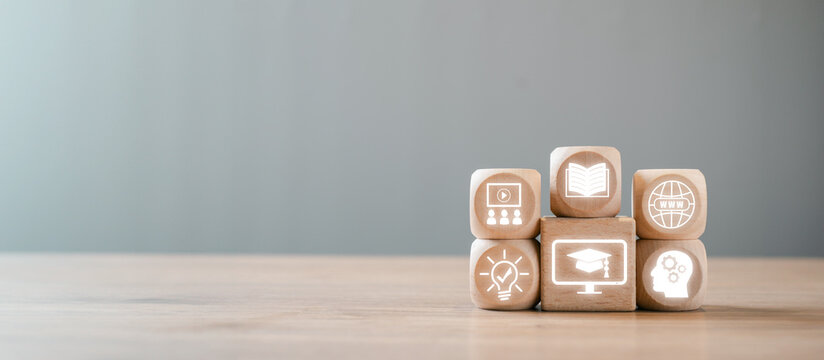 Wooden blocks with e-learning icons symbolizing online education, knowledge sharing, and digital learning concepts on a wooden table.