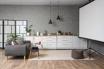 Interior of kitchen with counters, sofa and projector screen