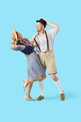 Happy mature waiters in traditional German clothes dancing on blue background