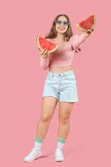 Beautiful young happy woman in sunglasses with slices of fresh watermelon on pink background