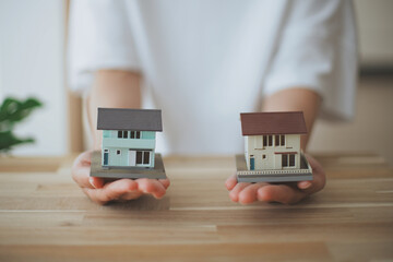 2つの住宅模型を持つ人の手元