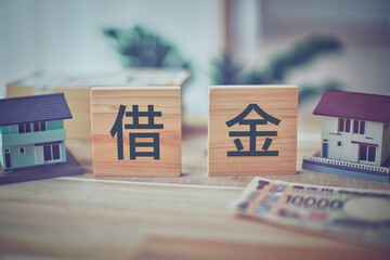 借金の文字と住宅模型 ビジネスイメージ
