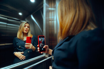 Woman Worried about her Looks Taking a Selfie in an Elevator. Concerned lady feeling bloated and...